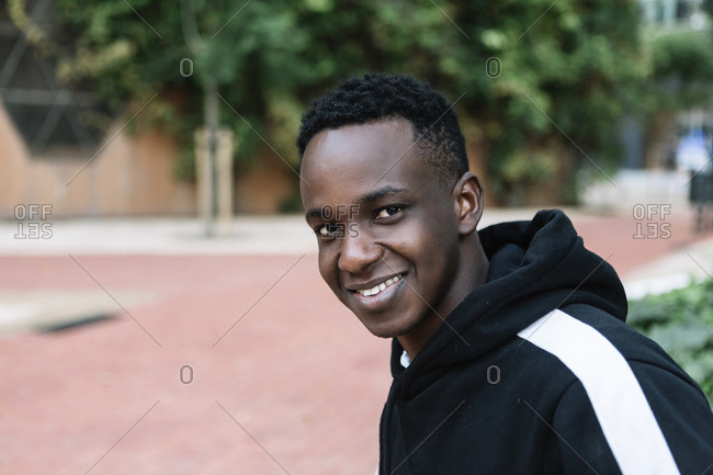 Side view of smiling African American man sitting outdoors