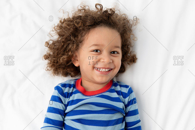 Portrait of joyful young boy with curly hair