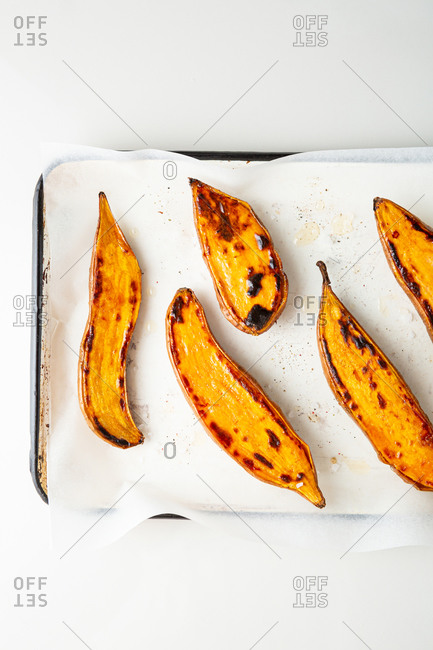 Overhead view of roasted sweet potatoes on baking tray