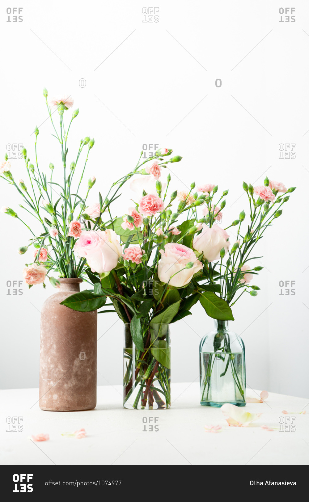Pink and white floral arrangements on table on light surface
