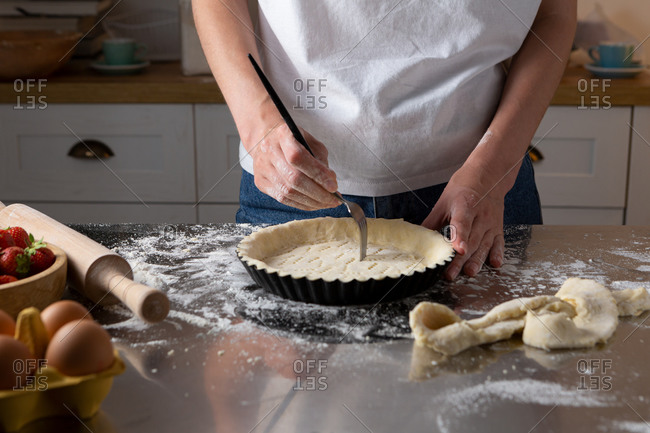 Woman making tart on domestic kitchen counter