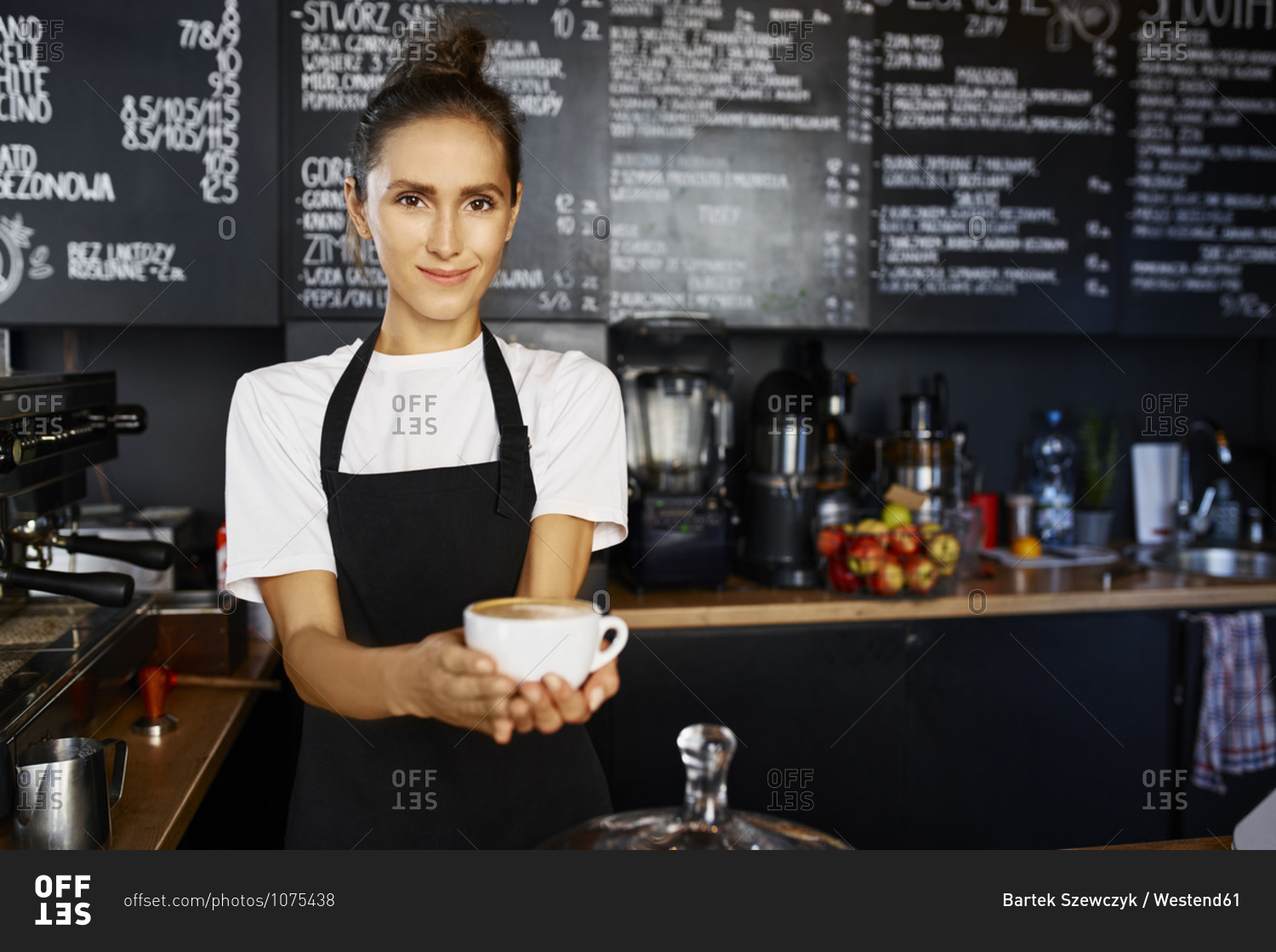Portrait of smiling waitress giving coffee at cafe
