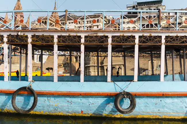 April 19, 2019: India- Uttar Pradesh- Varanasi- Old tourboat moored in front of city buildings