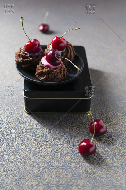 Mini gugelhupf with colorful cake cream and cherries