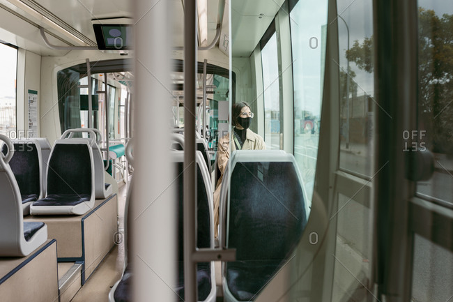 Woman wearing face mask traveling while sitting in tram