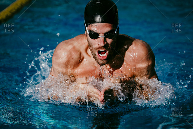 Young male swimmer swimming in pool