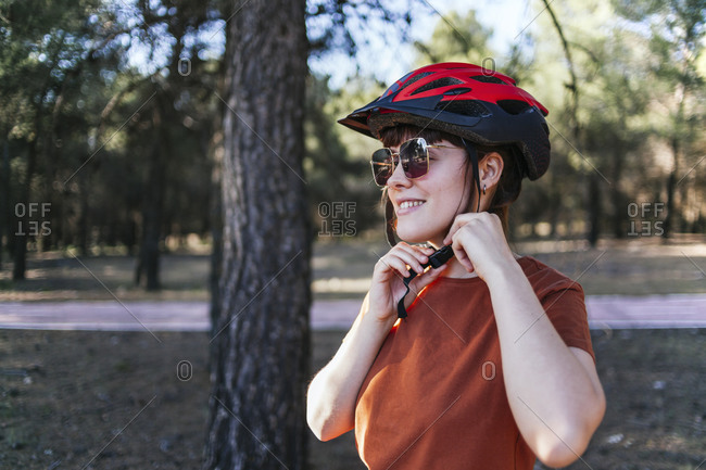 Smiling young woman wearing cycling helmet