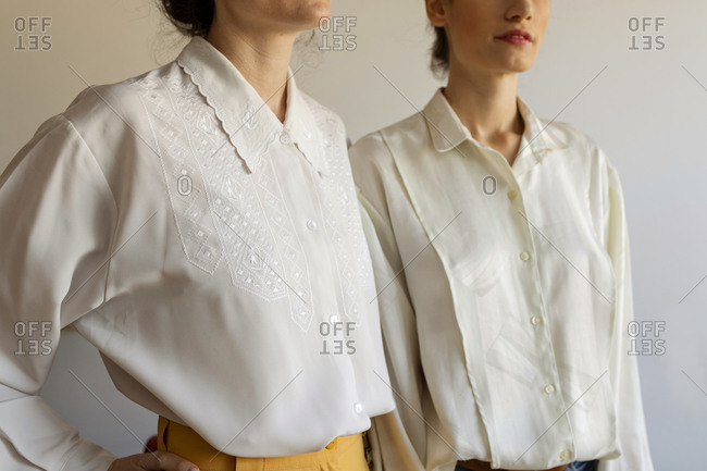 Female models wearing white shirt standing against wall at home