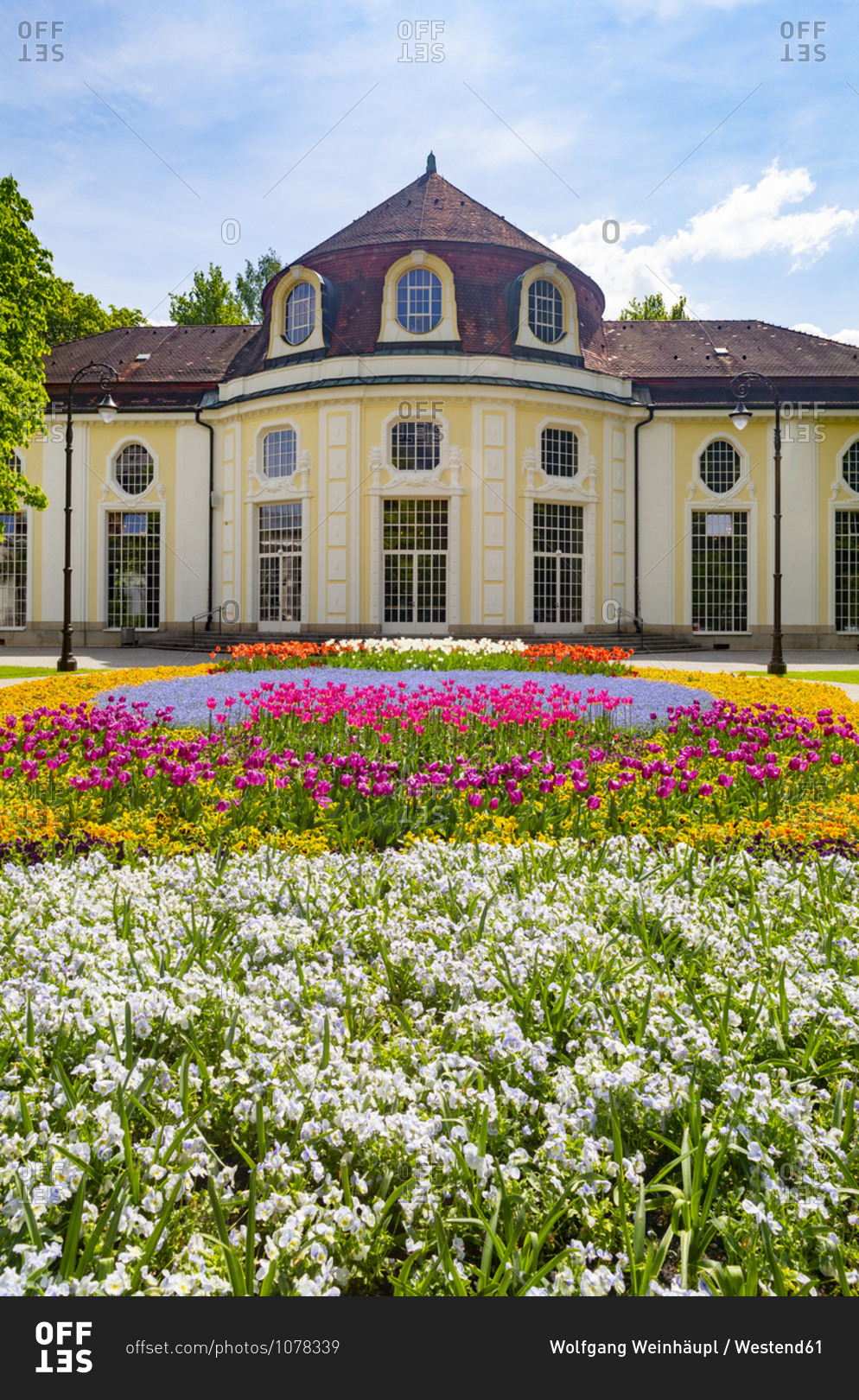 Germany- Bavaria- Bad Reichenhall- Colorful flowerbed in Royal Spa Garden with concert hall rotunda in background