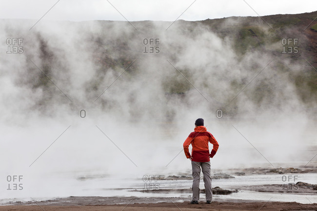 Woman standing by geothermal pools, South West Iceland