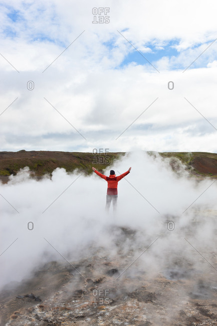 Man standing by geothermal pools, South West Iceland