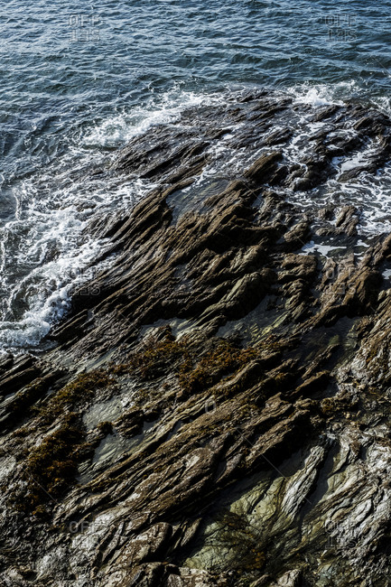 High angle view of waves washing around a rocky shore.