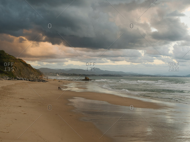 Almost empty beach in Biarritz with dark and epic sky in background