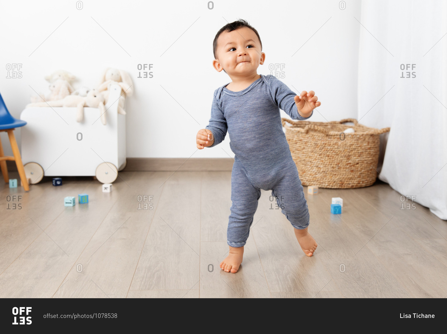 Cute toddler making first steps in playroom