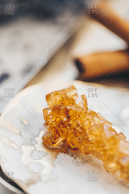Close up of a sugar crystal stick on tray with cinnamon