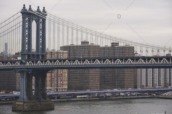 Side view of suspension Brooklyn bridge with cables and gates on cloudy day in New York