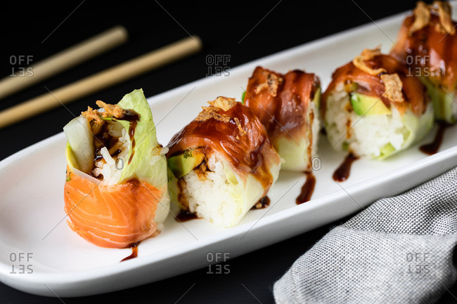 Closeup of palatable rolls filled with fresh turnip and garnished with teriyaki sauce