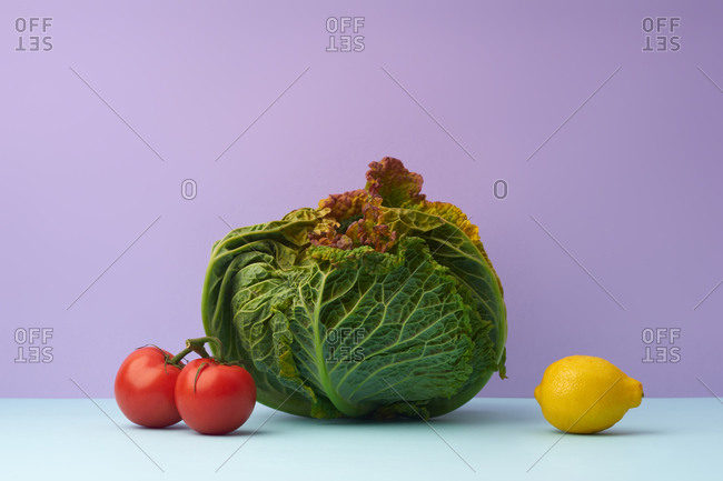 Still life with savoy cabbage, tomatoes and a lemon
