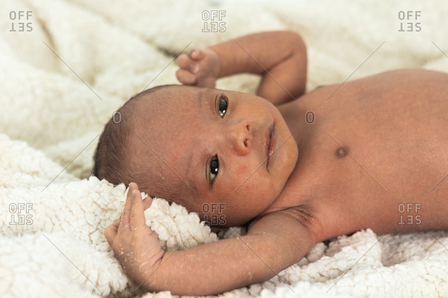 Tranquil adorable newborn baby lying on soft blanket