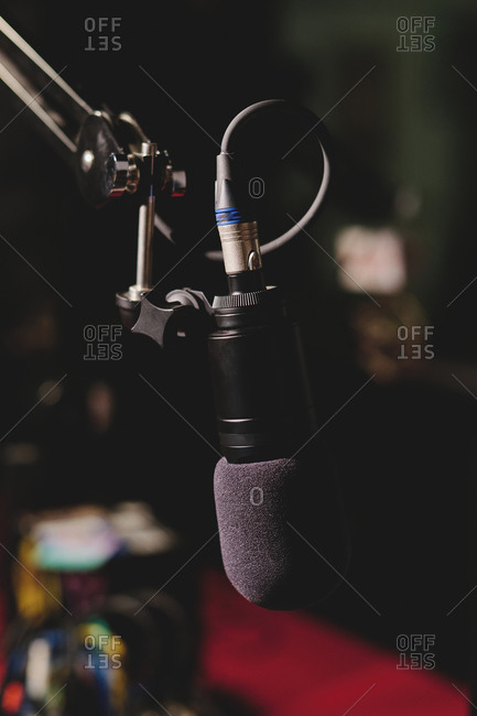 Contemporary soft black mic placed in modern radio station on dark blurred background