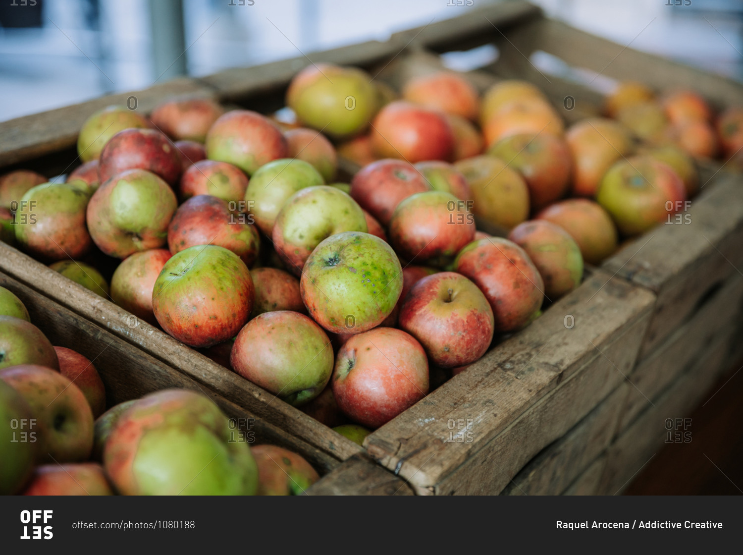 Wooden box filled with fresh natural bio organic apples placed on counter in local food market