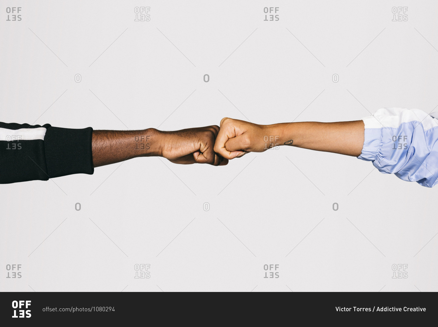 Close-up of a man's black fist bumping into a white woman's fist over white background
