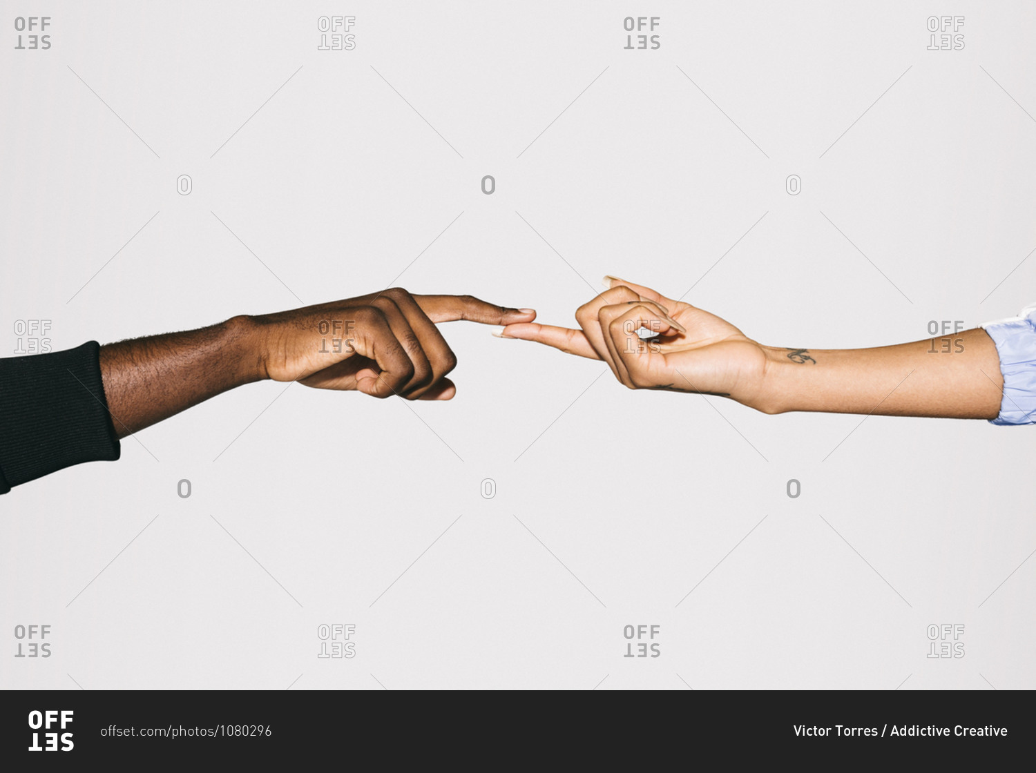 Close-up of a black man' touching white woman's finger over white background