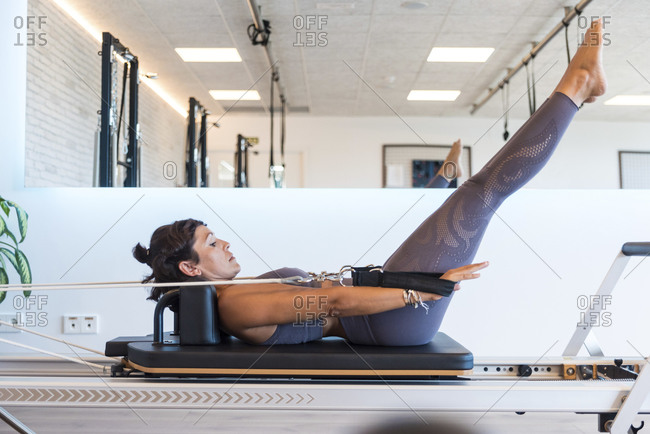 Side view of barefoot adult female in sportswear doing Shoulder Stand  exercise on Pilates reformer during training in modern gym Stock Photo -  Alamy