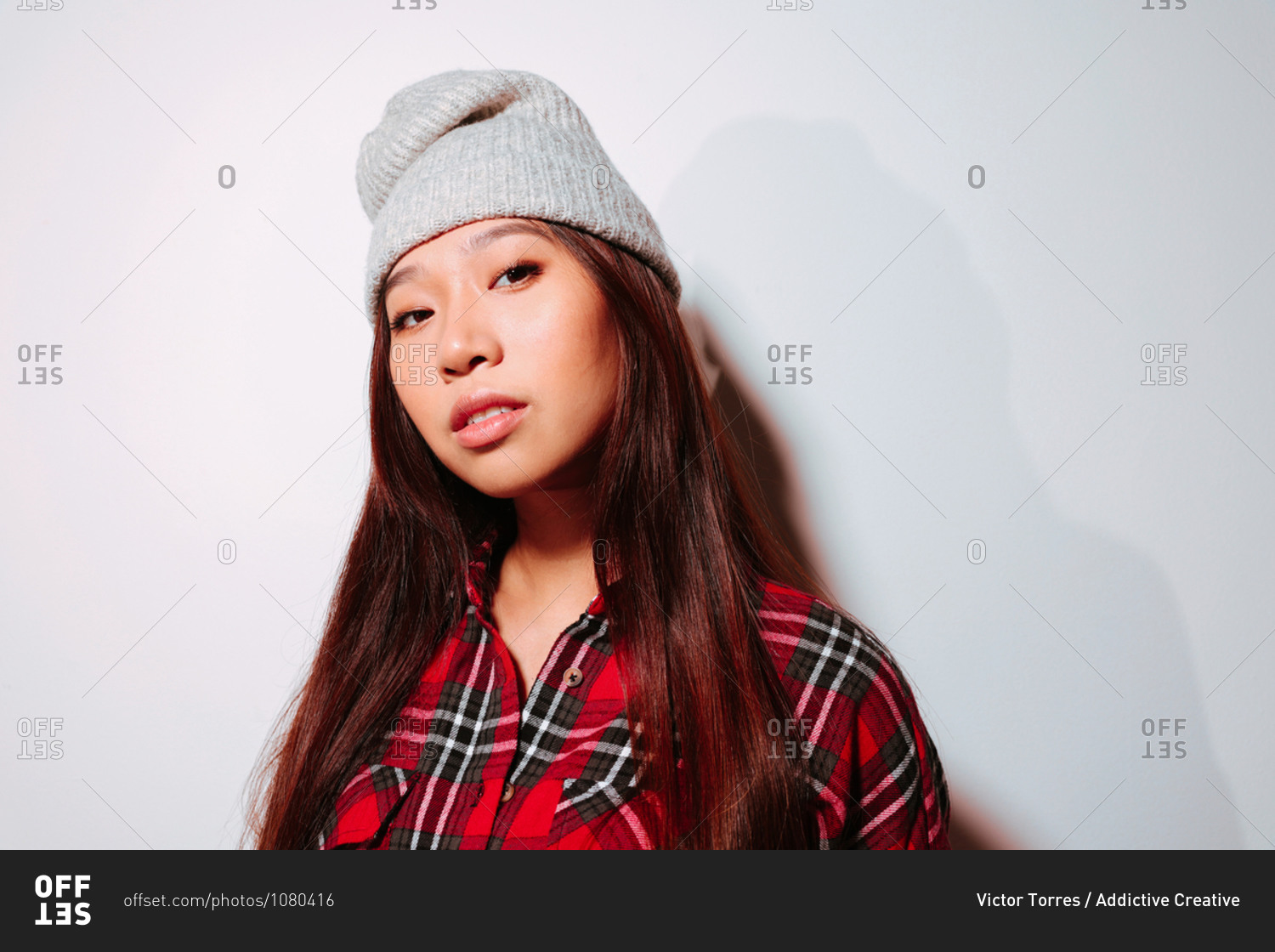 Close-up portrait of cheerful Asian young woman with serious face