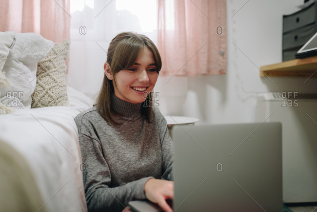 Young blonde woman sitting on a pillow stock photo - OFFSET