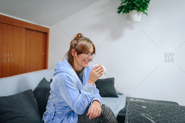 Young blonde woman sitting on a pillow stock photo - OFFSET