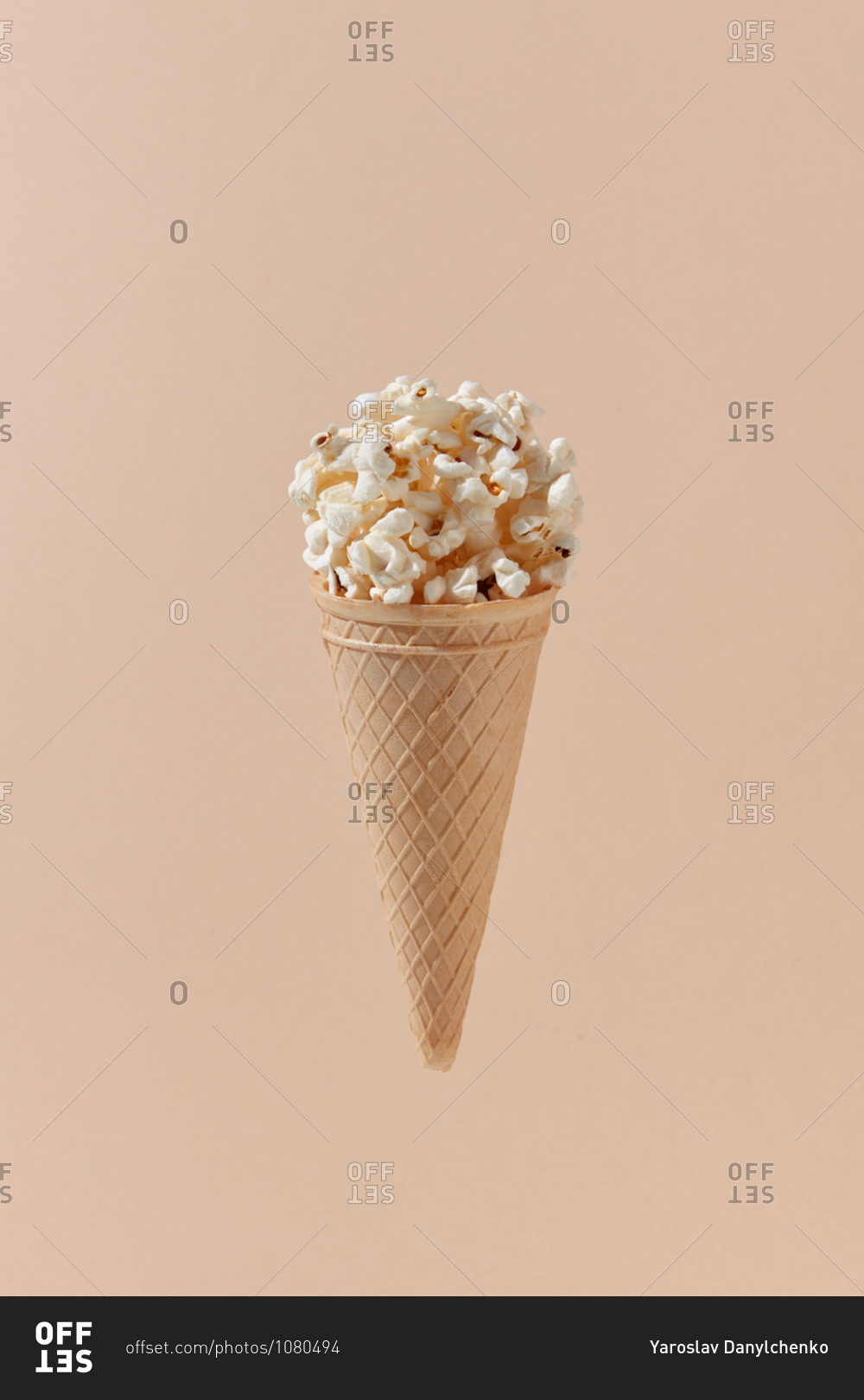 Tasty cooked classic popcorn in cone on beige background