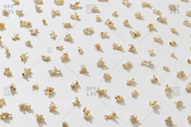 Closeup of appetizing cooked salty popcorn on white background, top view