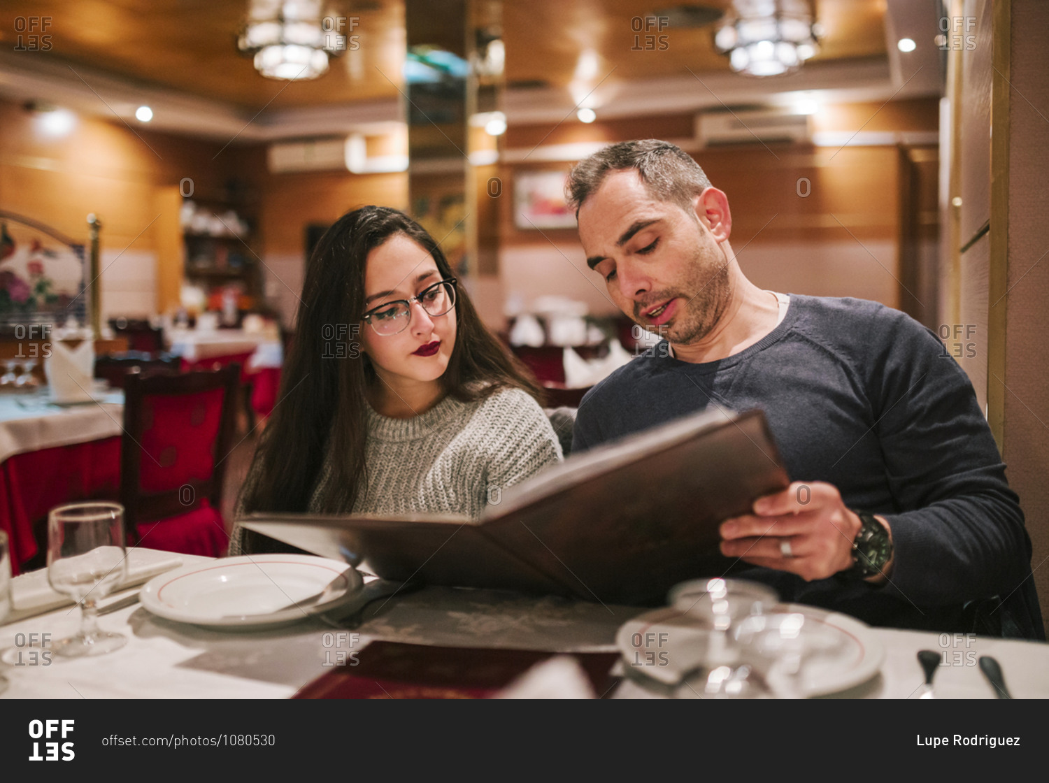 Father and daughter looking at the menu of a Chinese restaurant