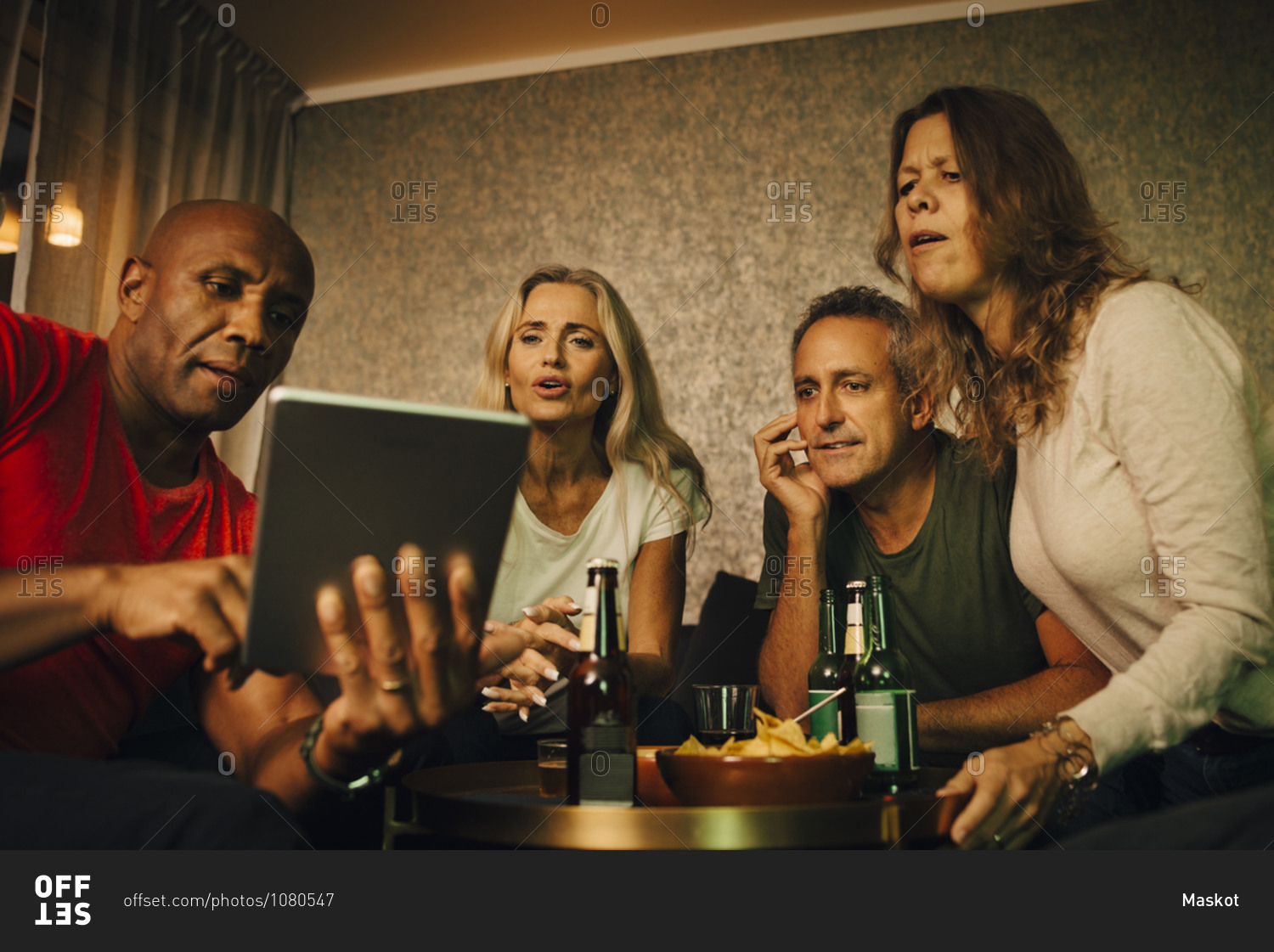 Man showing digital tablet to friends during sporting event