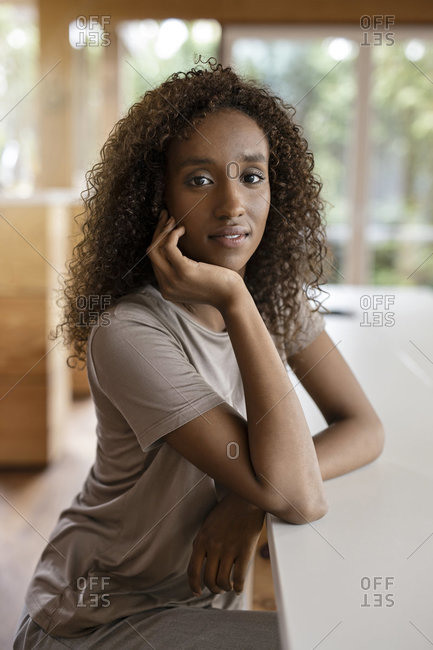 Woman sitting with head in hand at home