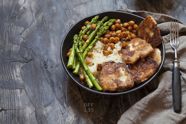 Bowl of rice with chick-peas- asparagus stalks and fried halloumi cheese