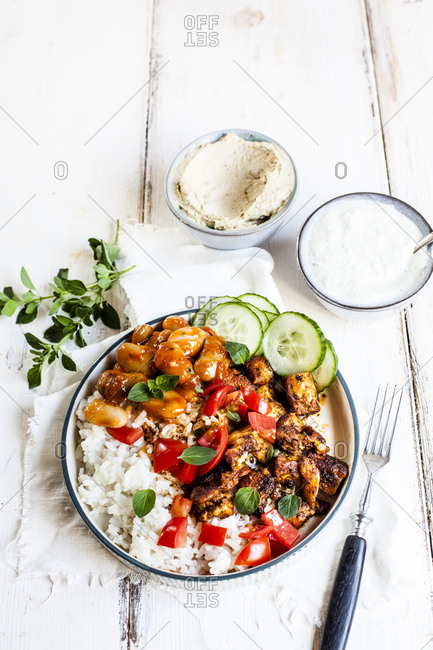 Bowl of Greek gyro with rice- fava beans- halloumi cheese- tomatoes and cucumbers