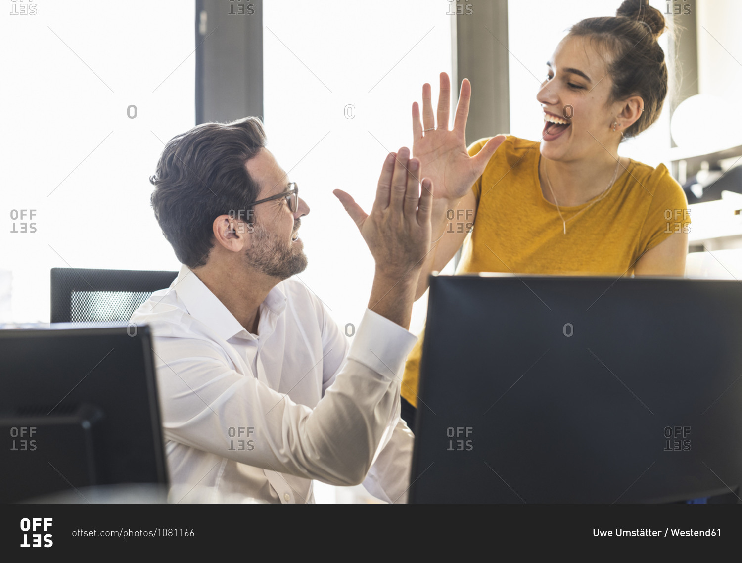 Business people giving high five while working together st office