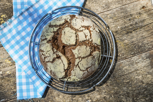 Round, freshly baked loaf of bread from above, weathered wood background