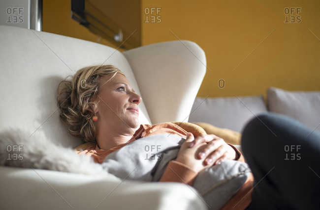 Woman looking away while relaxing on sofa at home