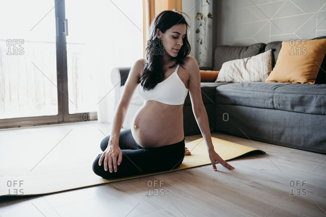 Mid adult pregnant woman exercising at home