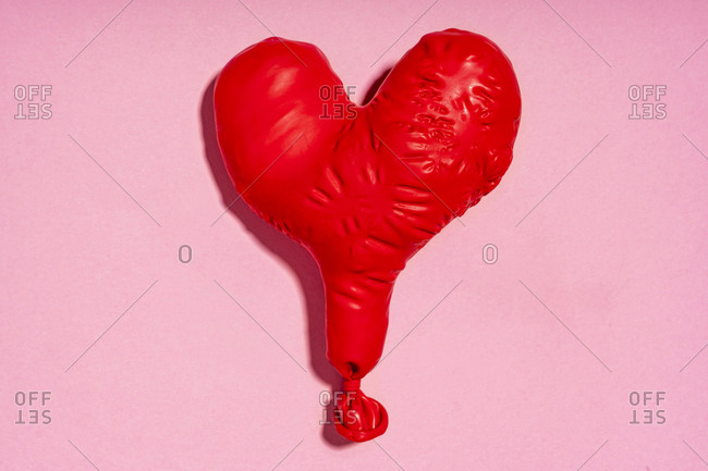 Studio shot of red heart shaped deflated balloon