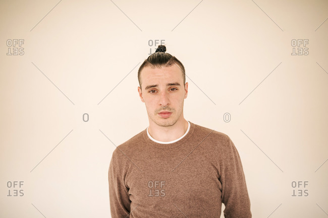 Young man standing against beige background