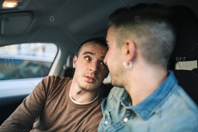 Affectionate gay couple spending leisure time in car