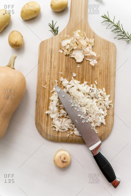 Studio shot of kitchen knife and chopped onions on cutting board