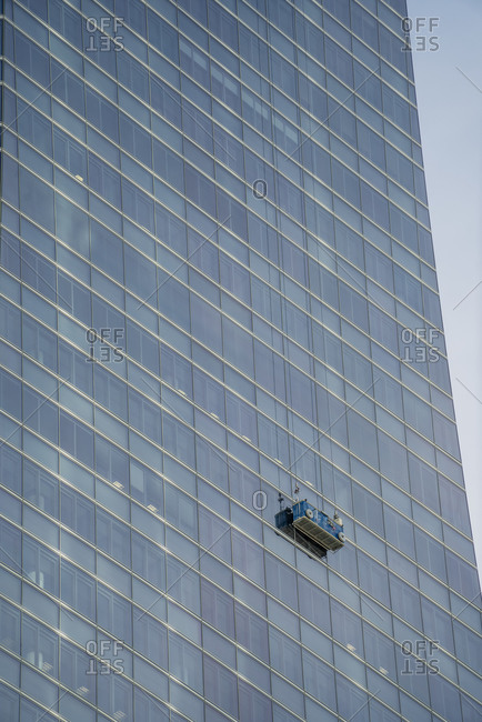 Spain- Madrid- Window cleaners platform hanging in front of skyscraper windows