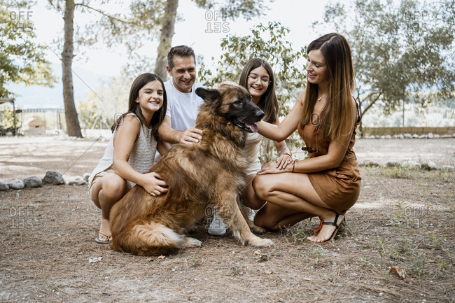 Smiling family with dog in park