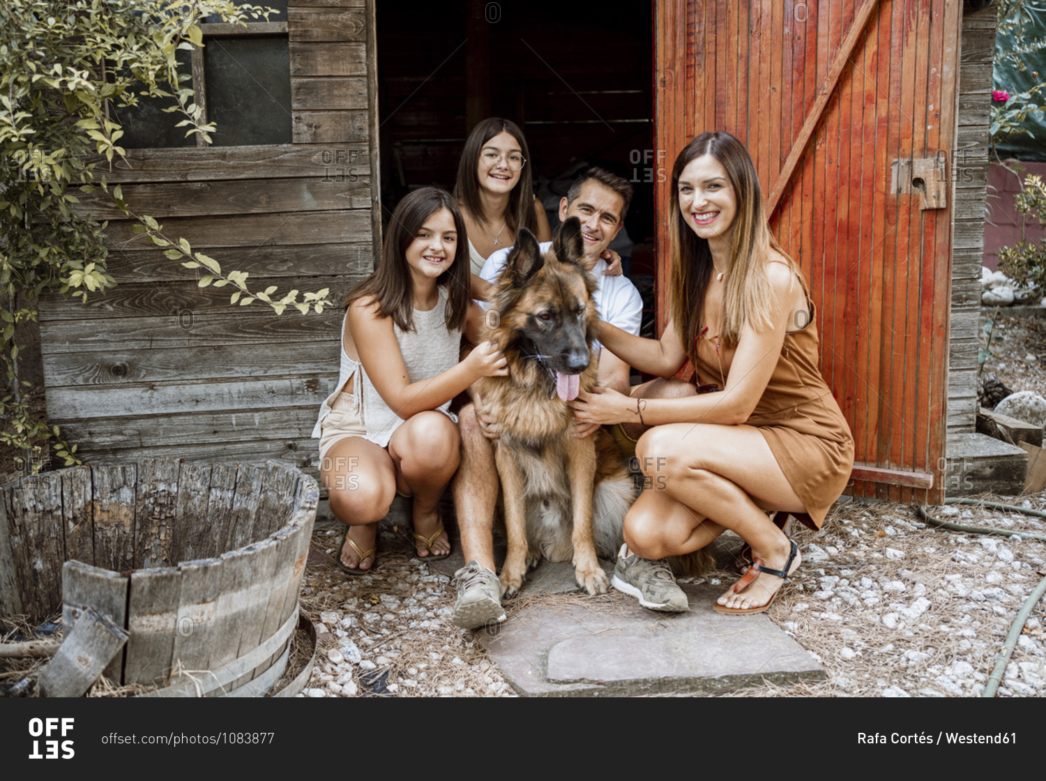 Smiling family with pet dog in back yard