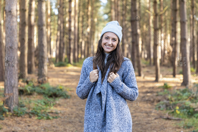 Smiling beautiful woman standing in Cannock Chase forest during winter season